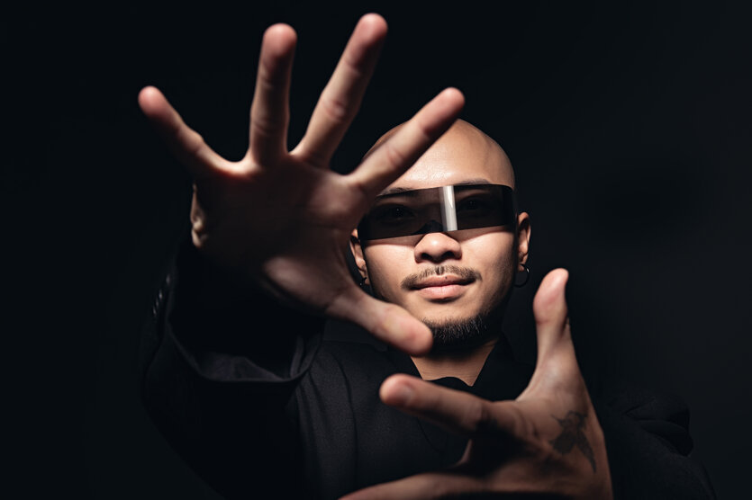 Porträt des Musikers Dzung mit Sonnenbrille und nah vor der Kamera gehaltenen Händen