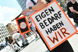 Demonstrantin mit Schild "Eigenbedarf haben wir"