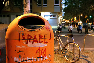 Ein Mülleimer mit der Schrift Israel und einem Pfeil Richtung Einwurf