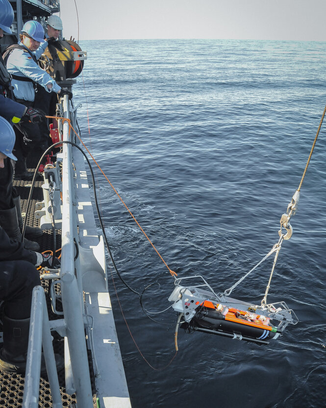 Eine Unterwasserdrohne wird zu Wasser gelassen.