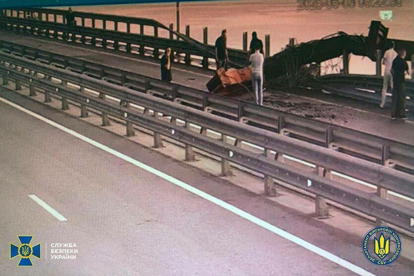 Menschen stehen auf einer Brücke und begutachten Schäden