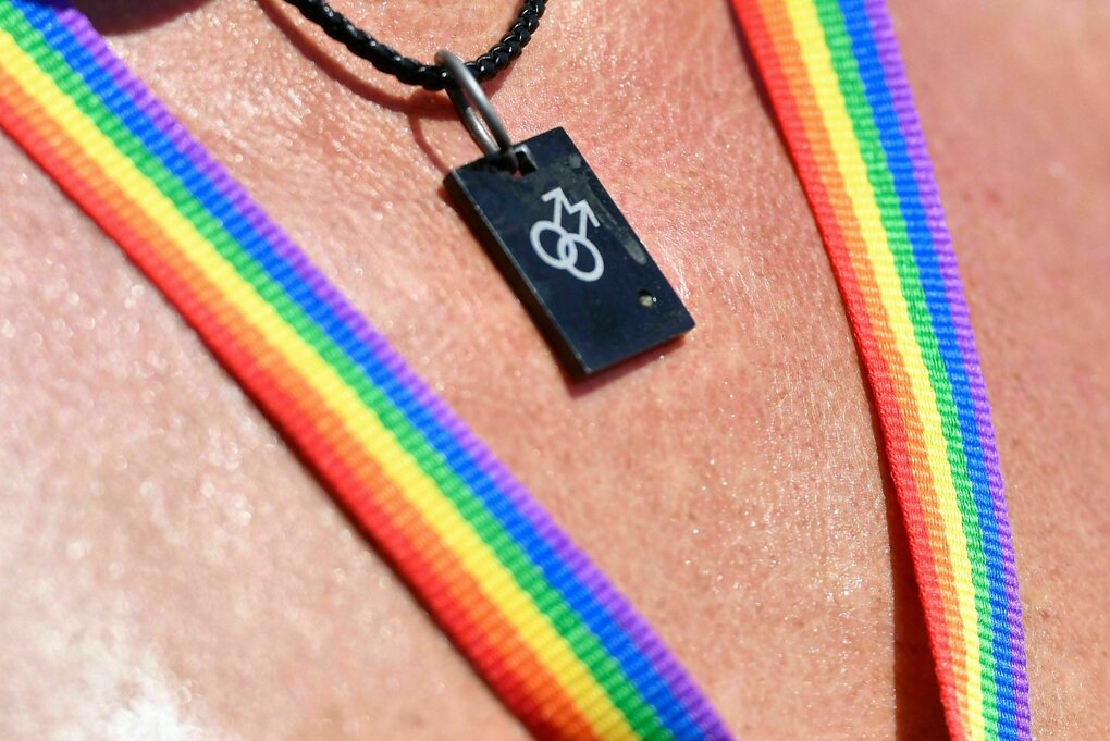 Eine Teilnehmer*in einer Csd-Parade trägt ein doppeltes Mars-Symbol