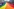 Ein großer Regenbogenfahne wird von vielen Menschen bei einem Umzug durch eine Stadtstraße getragen. Im Hintergrund steht ein prächtiges, schlossartiges Gebäude mit Türmen und goldenen Kuppeln. Die Menge ist bunt gekleidet, einige tragen Regenbogenaccessoires, und die Atmosphäre wirkt fröhlich und feierlich.