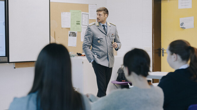 Julian Ströbl steht in Uniform in einem Klassenzimmer