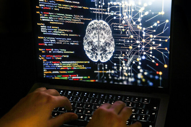 Eine Person arbeitet am Computer, auf dessen Bildschirm ein durch Künstliche Intelligenz generiertes Illustrationsbild mit Code verschiedener Programmiersprachen und einem neuronalen Netzwerk-Diagramm zu sehen ist