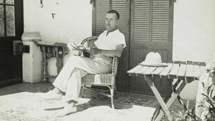 Thomas Mann sitzt in einem Korbsessel im Schatten vor einem Haus in Südfrankreich