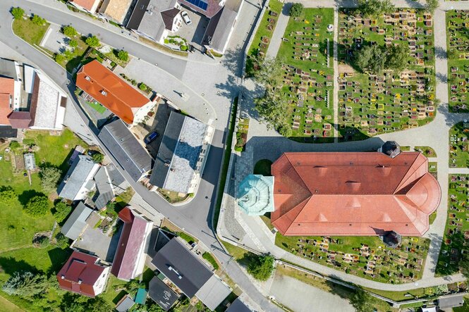 Vertikales Luftbild einer typisch deutschen Gemiende um eine Kirche herum, mit kleinem Friedhof