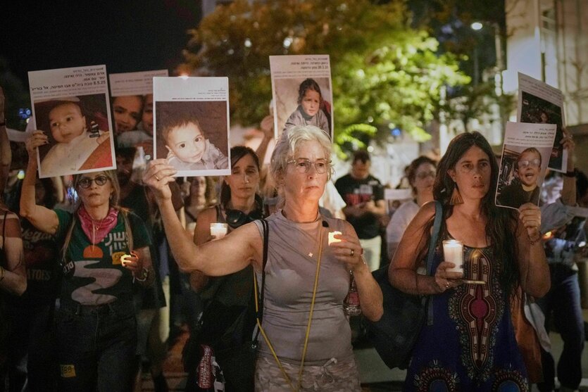 Frauen halten wärend eines Protestes in Israel Fotos getöteter palästinensischer Kinder hoch