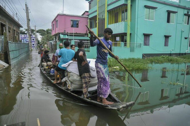 Aufgrund starker Regenfälle ist ein Fluss über die Ufer getreten. Boote sind das einzige Transportmittel für die Menschen, selbst auf den Straßen der Wohngebiete