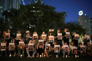 Israelische Aktivisiten haben sich in zwei Reihen positioniert und zeigen Fotos von getöteten Kindern aus Gaza