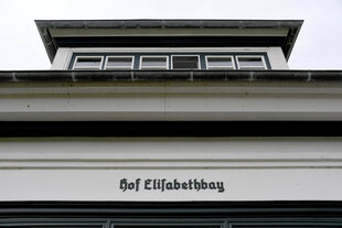 Ein weißes Gebäude mit schwarzem Dach und einer Inschrift 
