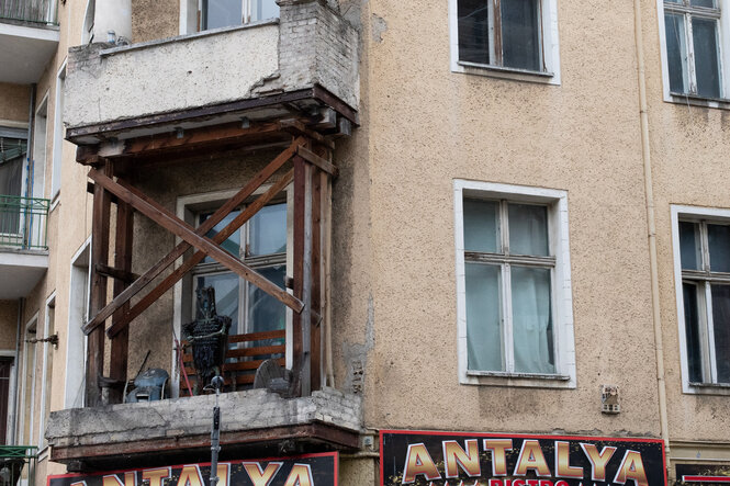 Das Eckhaus in der Warschauer Straße mit Holzstützen auf einem Balkon
