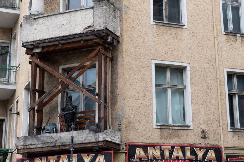 Das Eckhaus in der Warschauer Straße mit Holzstützen auf einem Balkon