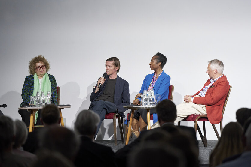 Auf dem Podium in der documenta-Halle sitzen die Kurator:innen Carolyn Christov-Bakargiev, Adam Szymczyk, Naomi Beckwith und Roger M. Buergel (v.l.n.r.)