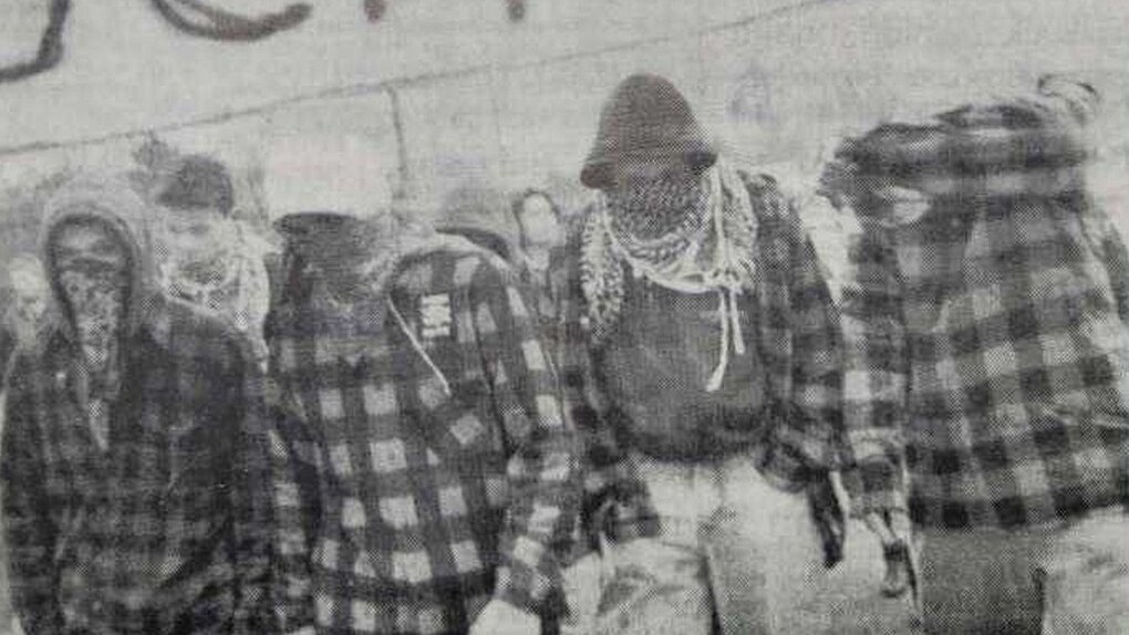 Ein Schwarz-weiß-Foto mit vermummten Jugendlichen
