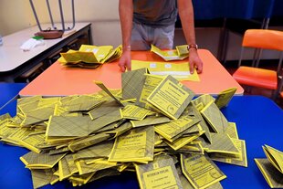 Stimmzettel mit der Aufschrift „Referendum Popolare“ liegen zur Auszählung auf einem Tisch