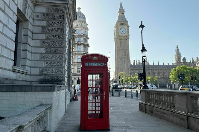 Eine rote Londoner Telefonzelle vorm Westminster-Palast