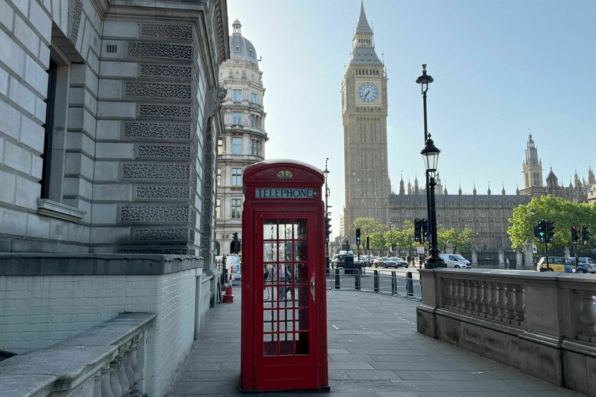 Eine rote Londoner Telefonzelle vorm Westminster-Palast