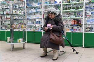 Eine Frau sitzt in einer russischen Apotheke