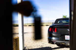 Ein schwarzer Ford Mustang Cabrio parkt vor einem Motel