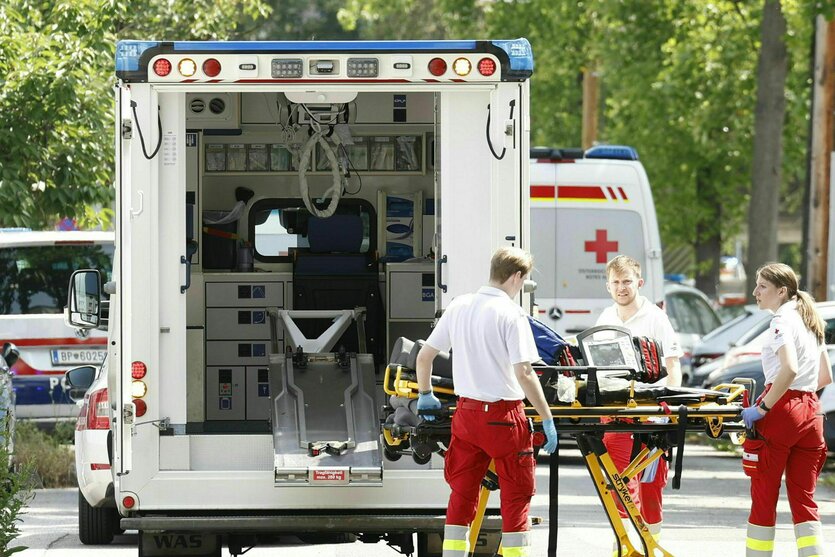 Rettungskräfte mit einer Trage an einem Krankenwagen