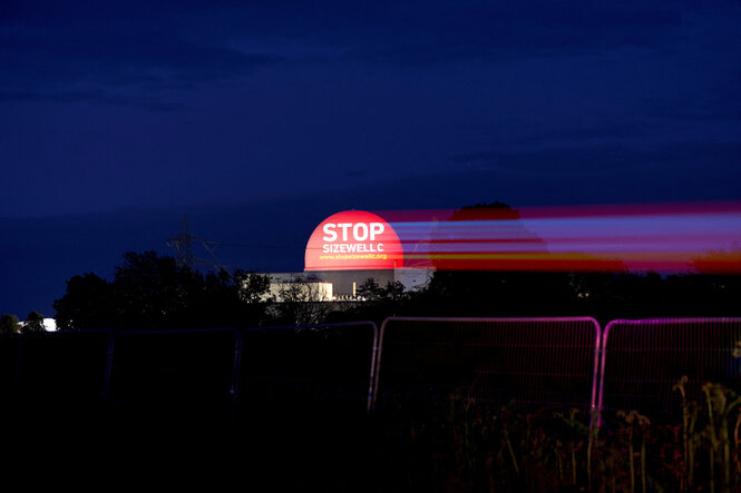 Projektion von "Stop Sizewell C" in dunkler Landschaft