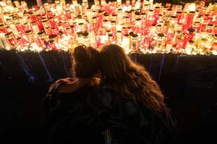 Zwei Menschen vor hunderten brennenden Kerzen