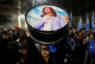 Eine Frau hält eine Trommel mit dem Foto von Cristina Kirchner in die Höhe