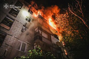 Aus einem Stockwerk eines Hochhauses schlagen Flammen