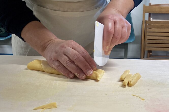 Eine Person stellt Pasta her.