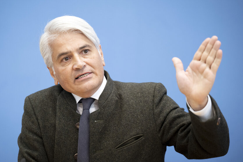 Ein Mann gestikuliert mit seiner linken Hand