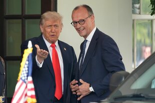 Zu sehen sind Donald Trump und Friedrich Merz im Weißen Haus, in die Kamera lächelnd.