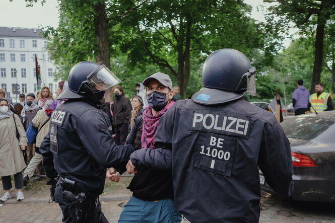 Zwei Polizisten nehmen einen Mann fest