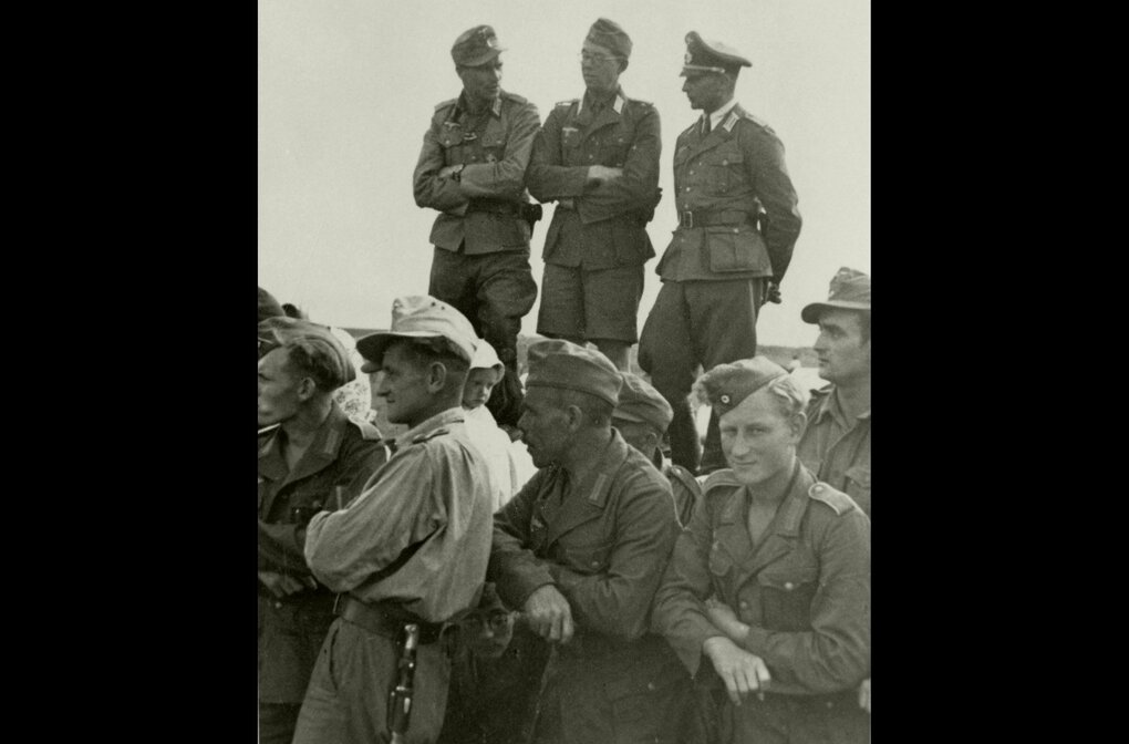 Eine historische Aufnahme zeigt deutsche Soldaten in Uniform mit Kriegsfreiwilligen um 1941