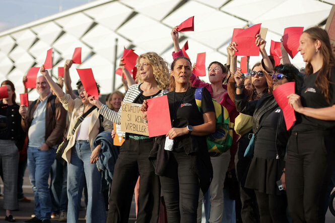 Mehrere Menschen die vor dem Stadion rote Karten hochheben