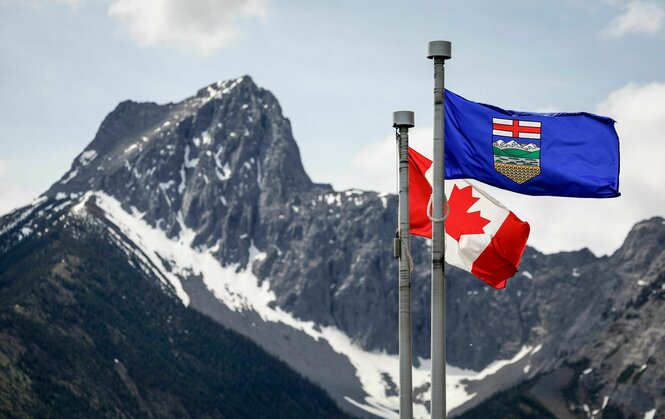 Eine kanadische Flagge (l) und eine Flagge von Alberta flattern im Wind, im Hintergrund der Wedge Mountain am Ort des G7-Gipfels der Staats- und Regierungschefs