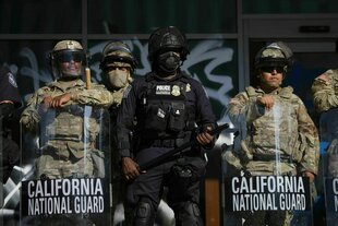 US-Zoll- und Grenzschutzbeamte und Soldaten der Nationalgarde sind an den Eingängen des Bundesgebäudes in Los Angeles postiert, während sich Demonstranten während einer Demonstration als Reaktion auf eine Reihe von Razzien der US-Einwanderungs- und Zollbe