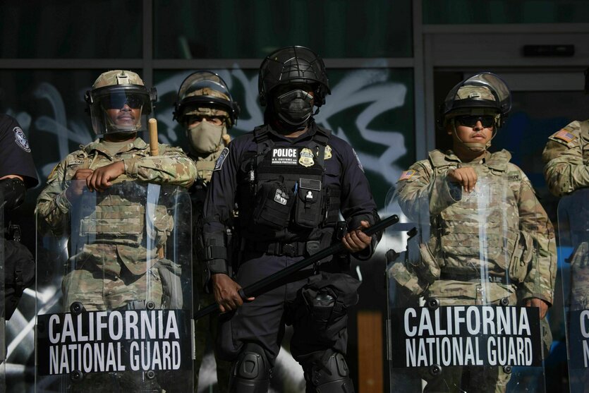 US-Zoll- und Grenzschutzbeamte und Soldaten der Nationalgarde sind an den Eingängen des Bundesgebäudes in Los Angeles postiert, während sich Demonstranten während einer Demonstration als Reaktion auf eine Reihe von Razzien der US-Einwanderungs- und Zollbehörden (ICE) im ganzen Land versammeln