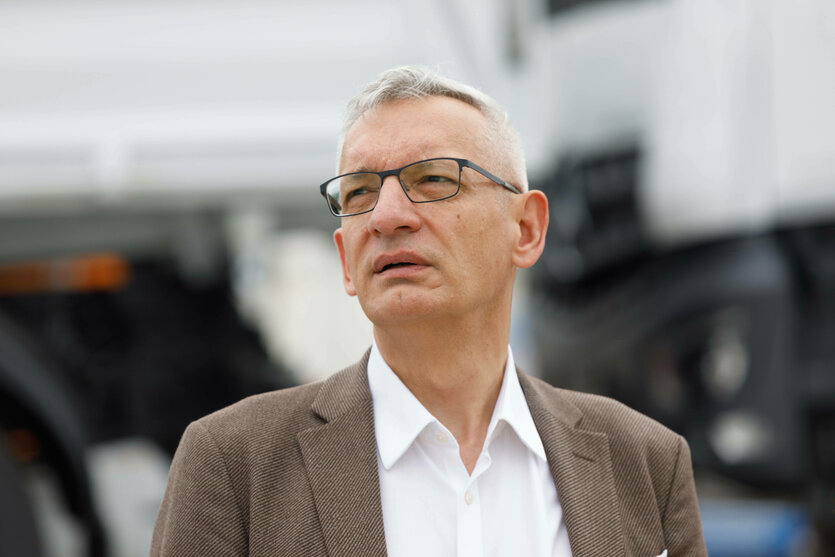 Ein Mann mit weißem Hemd und braunem Jacket