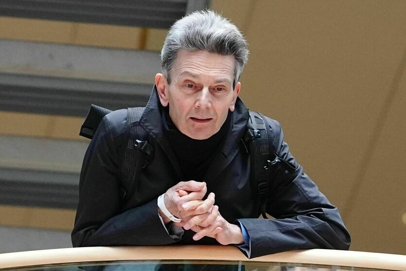 Ein Mann leht sich an ein Geländer