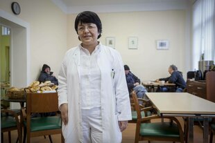 Eine Frau in weißem Kittel steht in einem Raum des Gesundheitszentrums