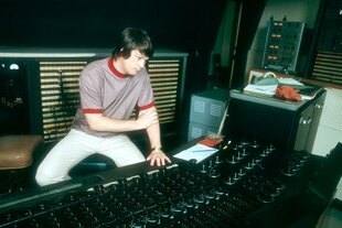 Brian Wilson sitzt an einem großen Mischpult in einem Tonstudio