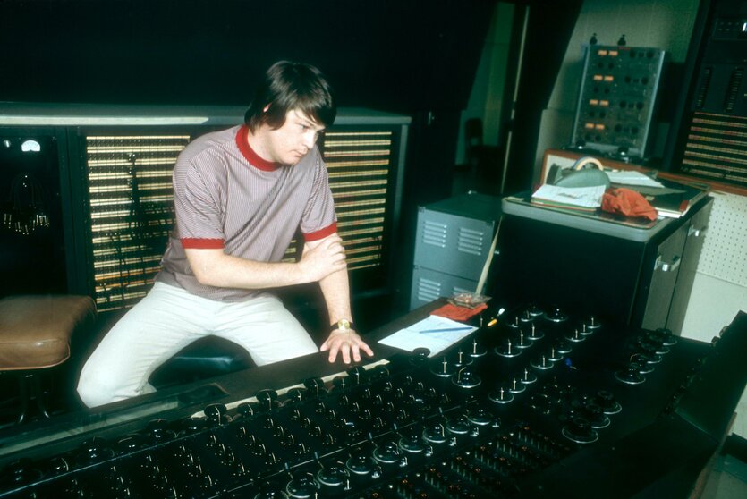 Brian Wilson sitzt an einem großen Mischpult in einem Tonstudio