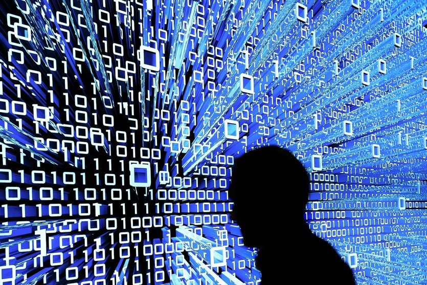 Person geht an einem Leuchtdisplay mit Zahlen und Cyber Ästhetik vorbei.