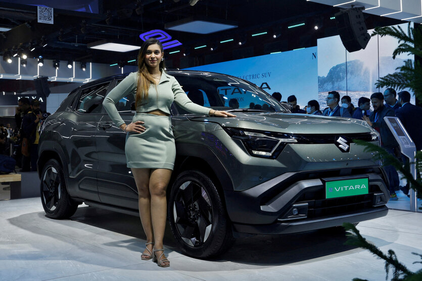 Ein erwachsenes Model posiert neben einem neuen SUV auf einer Auto Show. Die haube reicht etwa bis zum Bauchnabel