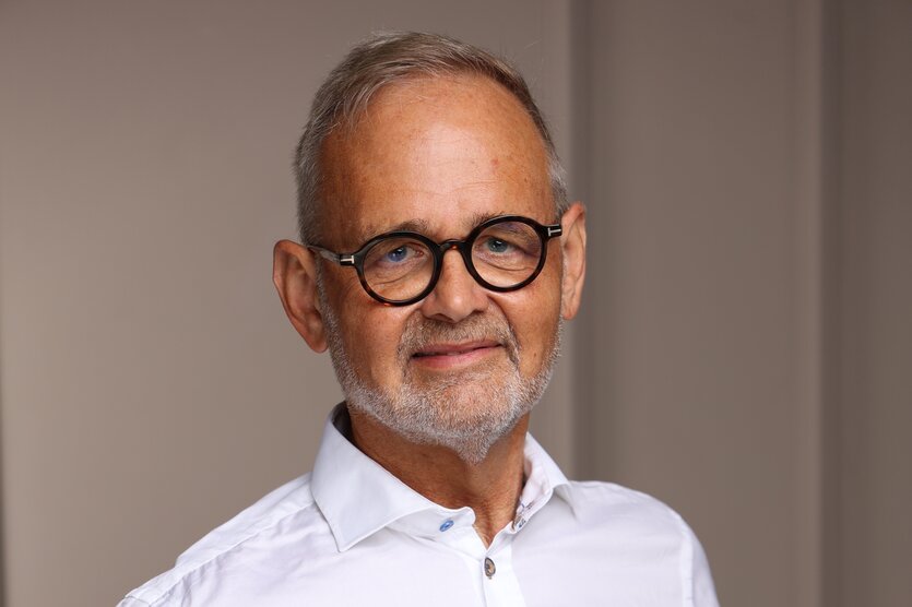 Porträt von Joachim Volz, mit leichtem Bart, dicker runder Brille und leicht verzweifeltem Blick