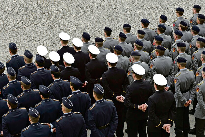 Männer in Uniformen stehen in gleichförmigen Reihen.