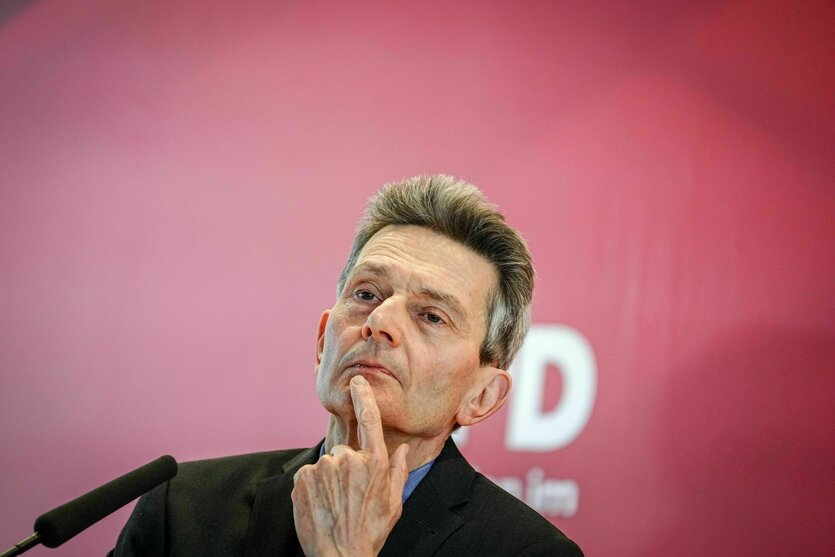 Ein Mann hält skeptisch einen Finger an sein Kinn