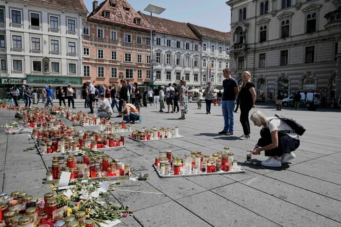 Menschen gedenken der Opfer eines Amoklaufs in einer Schule, in der ein ehemaliger Schüler zwei Tage zuvor das Feuer eröffnet hatte, auf dem Hauptplatz in Graz.