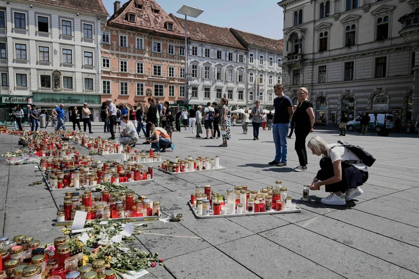 Menschen gedenken der Opfer eines Amoklaufs in einer Schule, in der ein ehemaliger Schüler zwei Tage zuvor das Feuer eröffnet hatte, auf dem Hauptplatz in Graz.